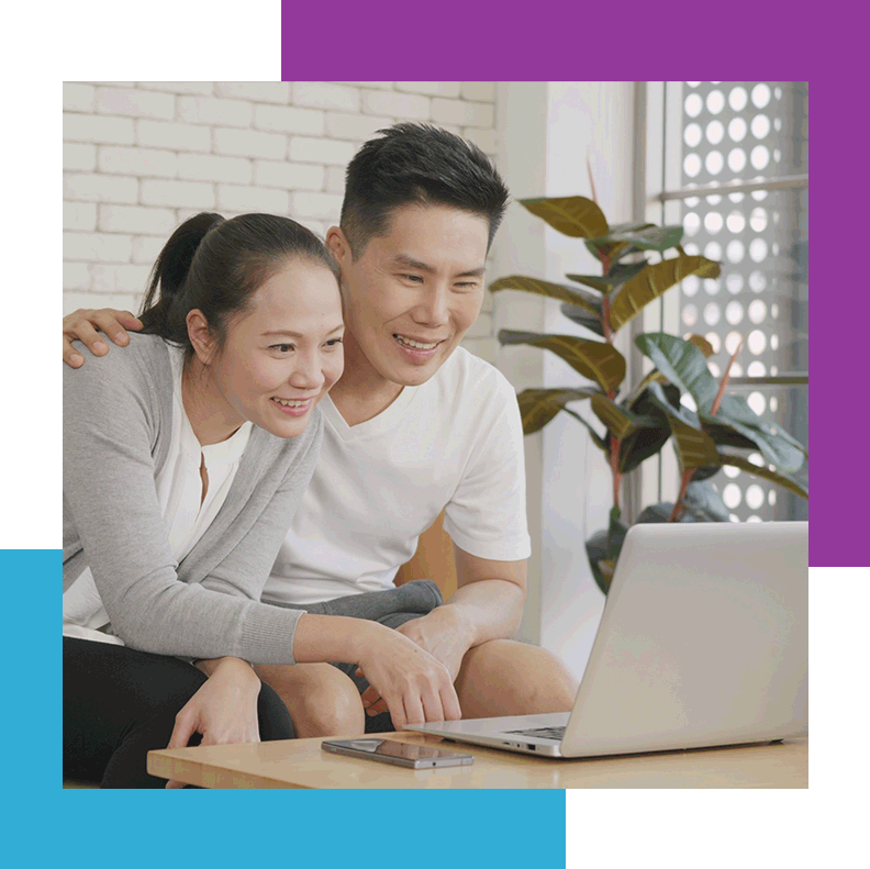 couple smiling and looking at laptop screen